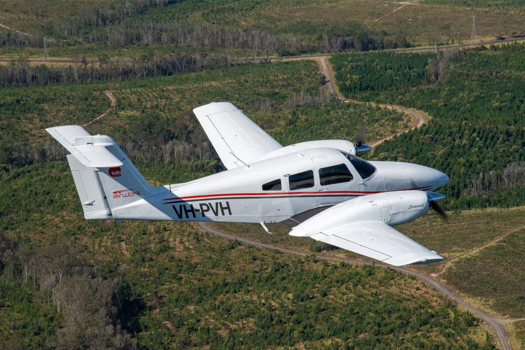 Piper Seminole aeroplane cruising above land